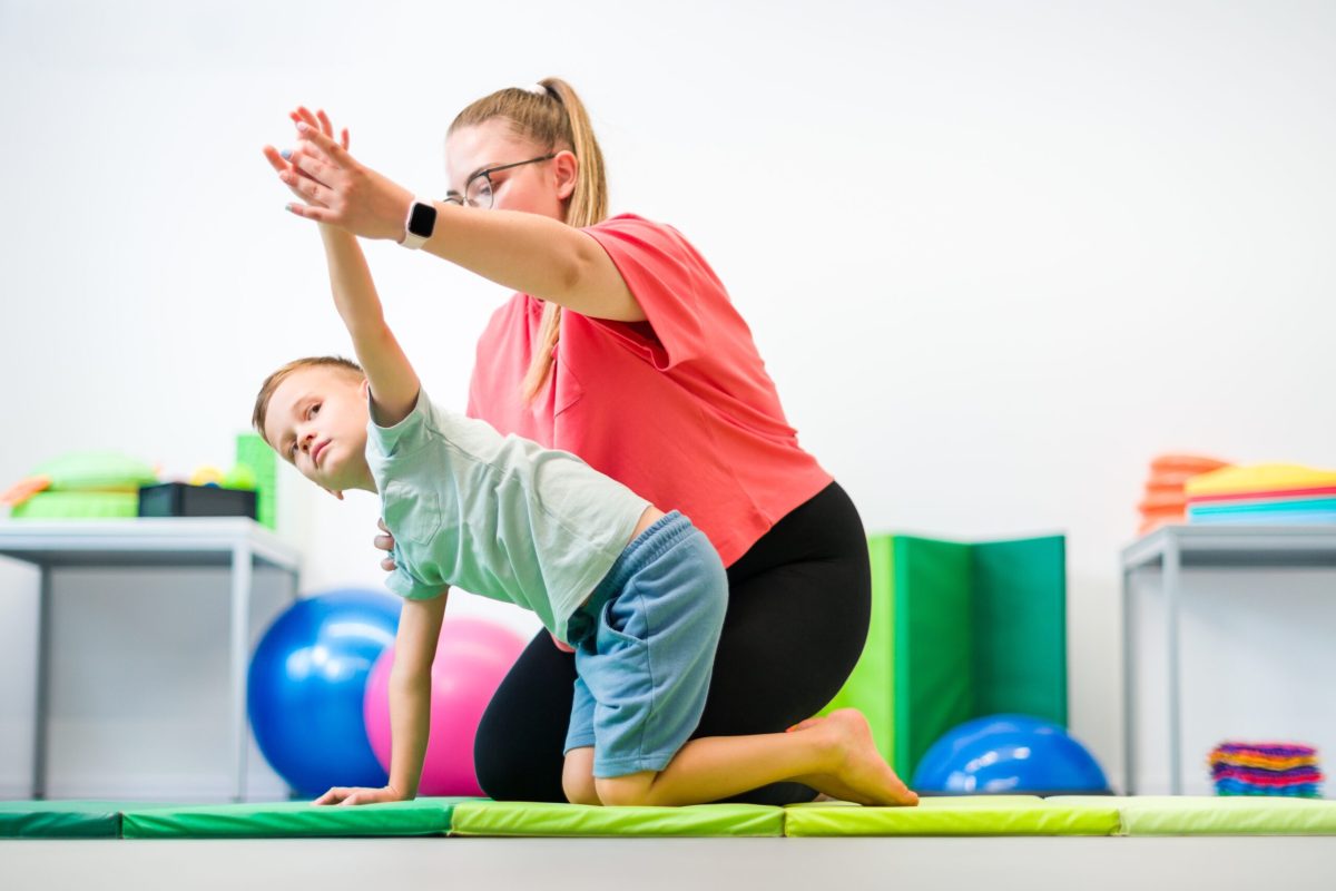 Young,Boy,Exercising,With,Female,Physical,Therapist,During,Therapy,Session.